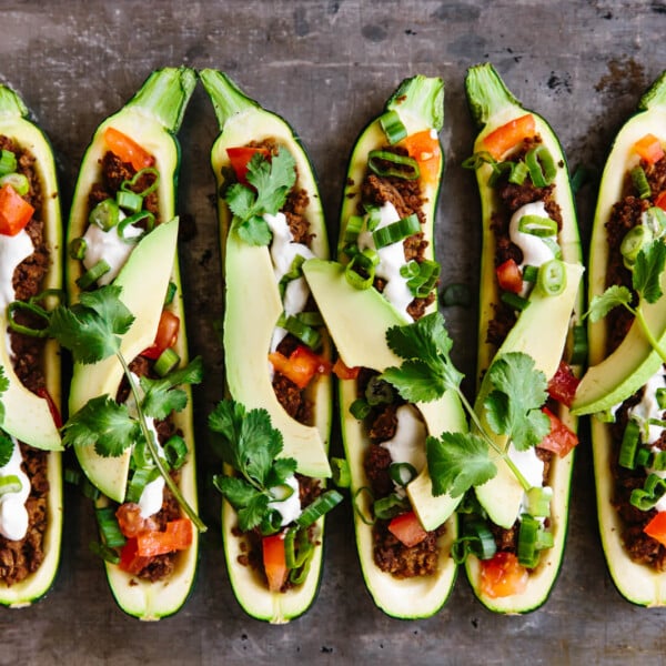 Several taco stuffed zucchini boats on a baking sheet.