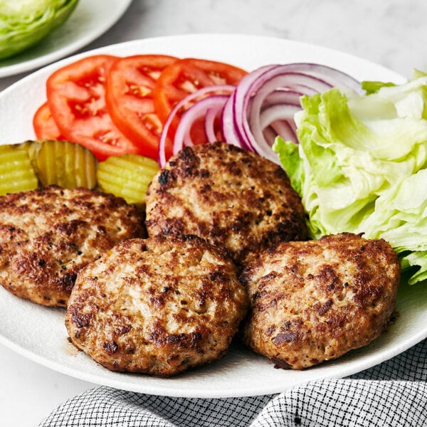 A white plate of turkey burger patties