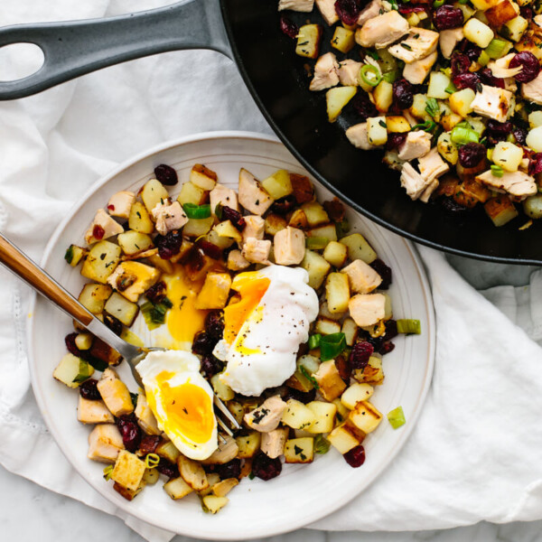 A serving of turkey cranberry hash on a plate with poached egg.