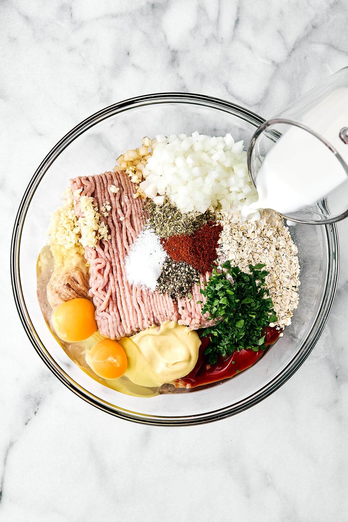 Mixing ground turkey meatloaf in a bowl.