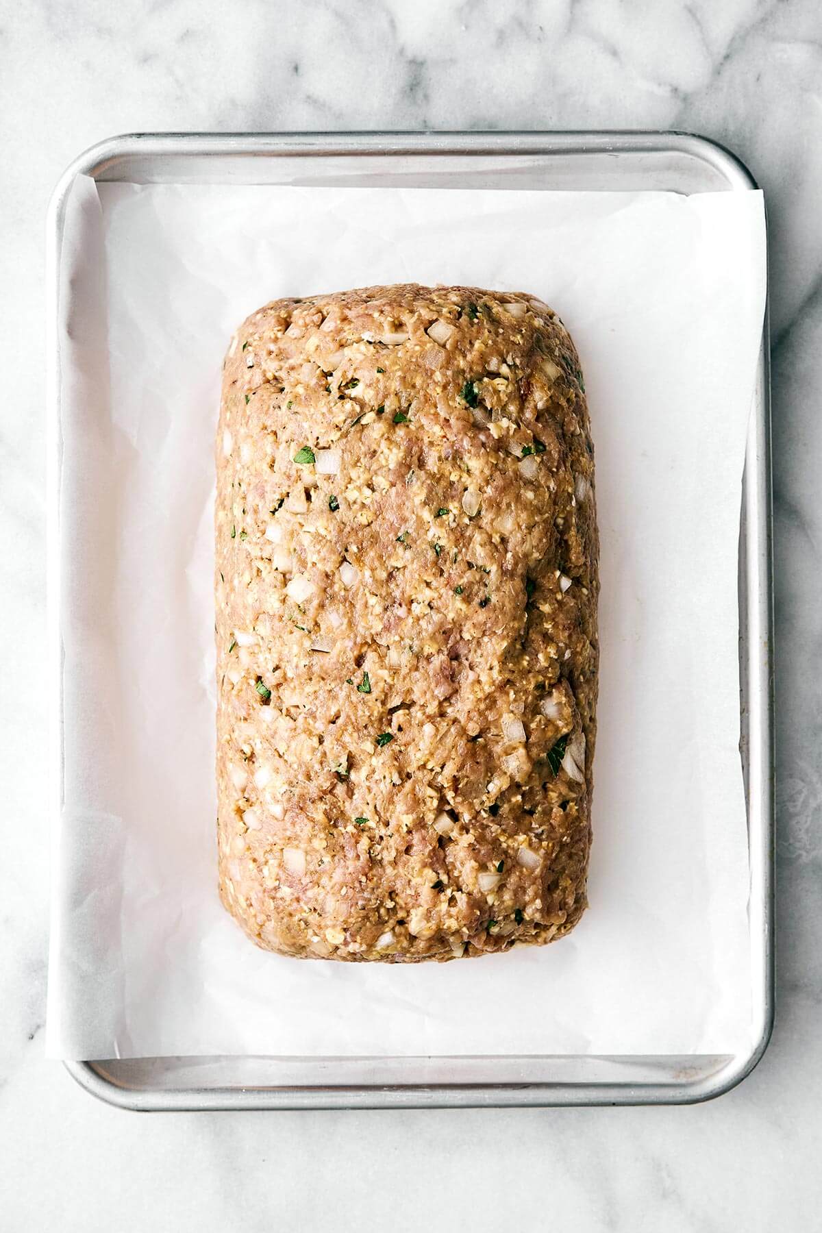 Forming a turkey meatloaf on baking pan.