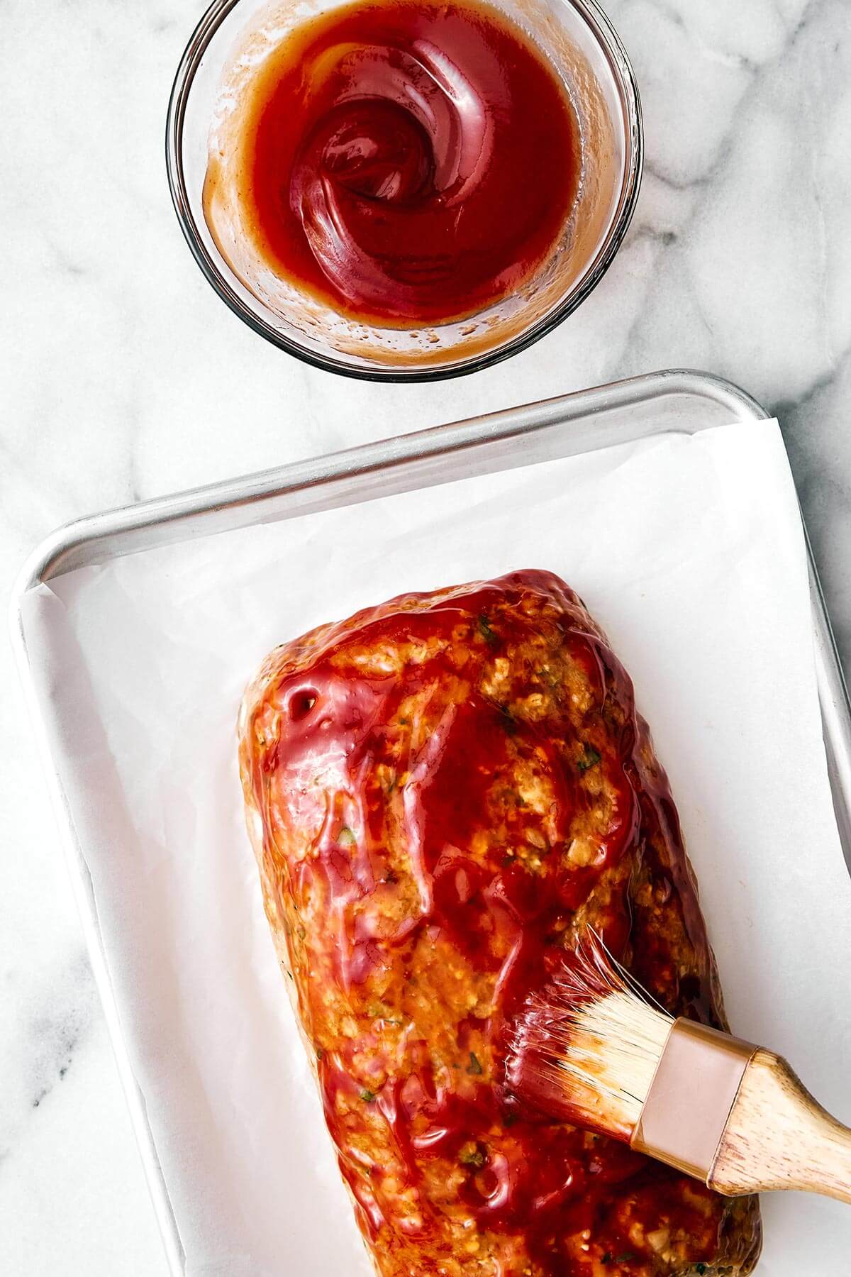 Brushing glaze on a turkey meatloaf.