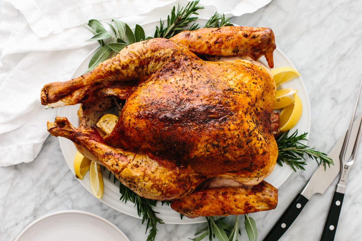 Thanksgiving turkey on a plate with sage and lemons.