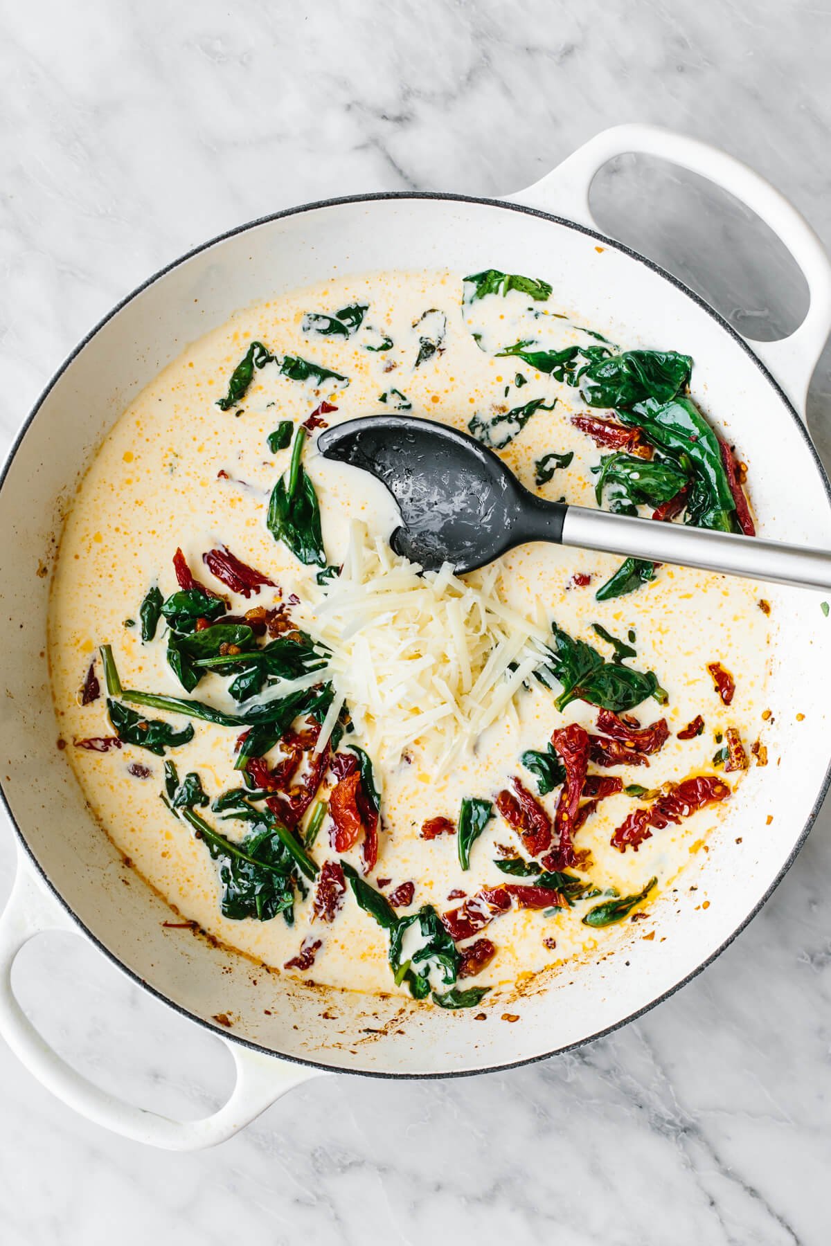 Adding cream into a pan for tuscan chicken