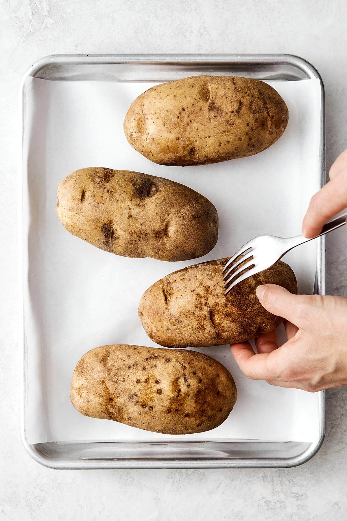 Poking holes in potatoes.