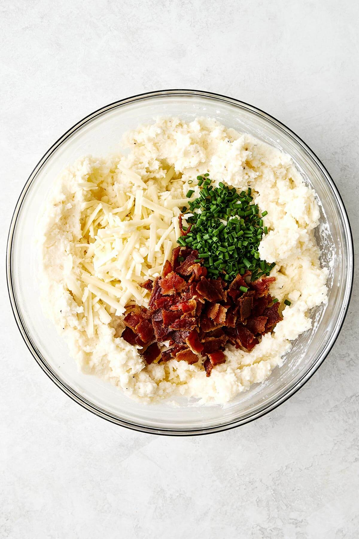 Mashed potato filling with toppings in a bowl.